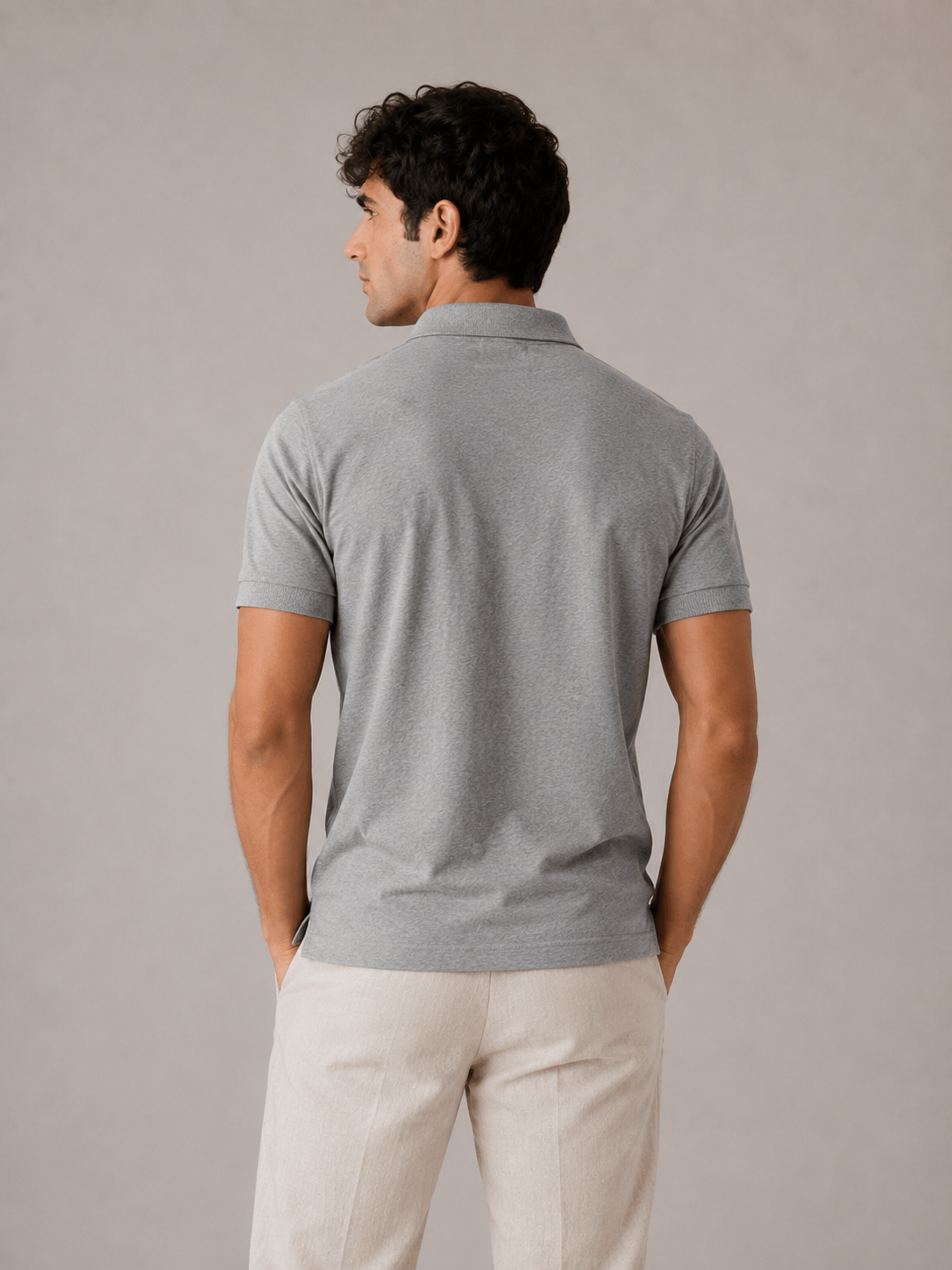 Men’s grey textured cotton polo shirt, three-quarter angle view on model, heather yarn detail
