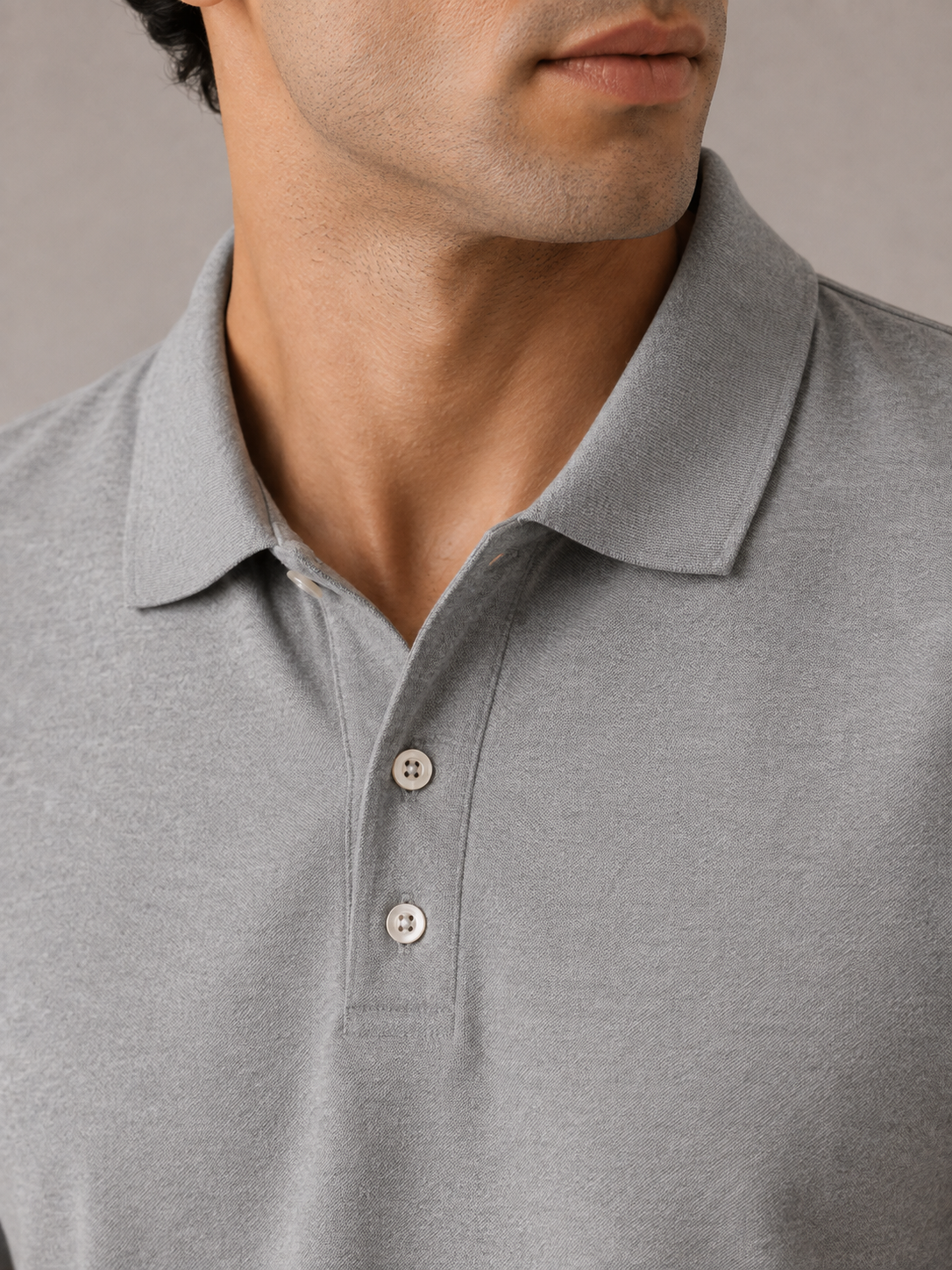 Men’s light grey Airtex polo shirt, back view on model, clean minimal shoulder line and drape