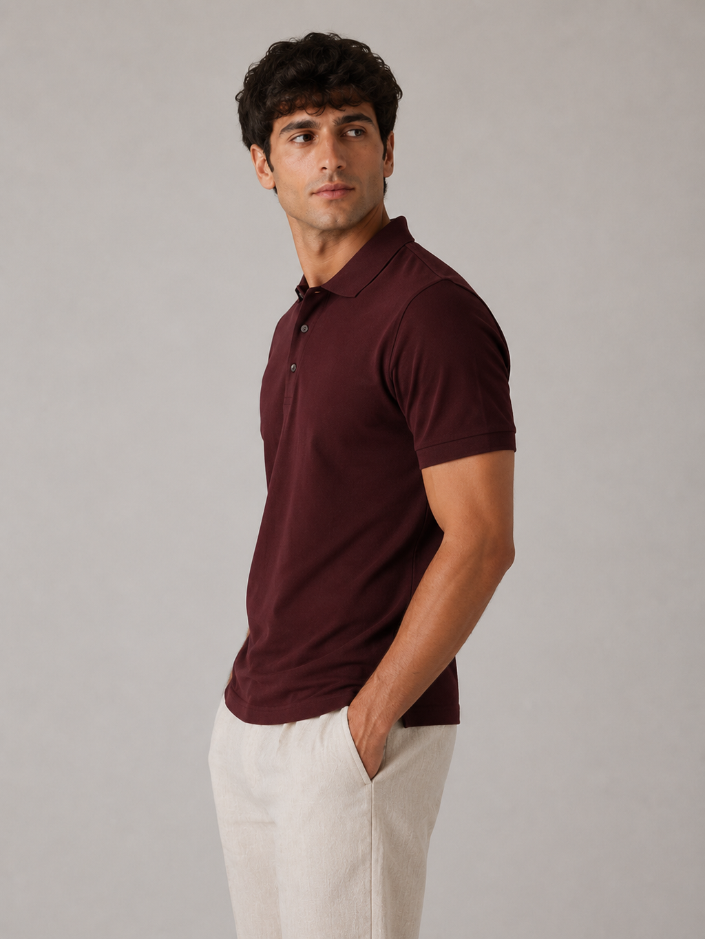Men’s burgundy red polo shirt, side profile view on model, clean ribbed sleeve cuff fit
