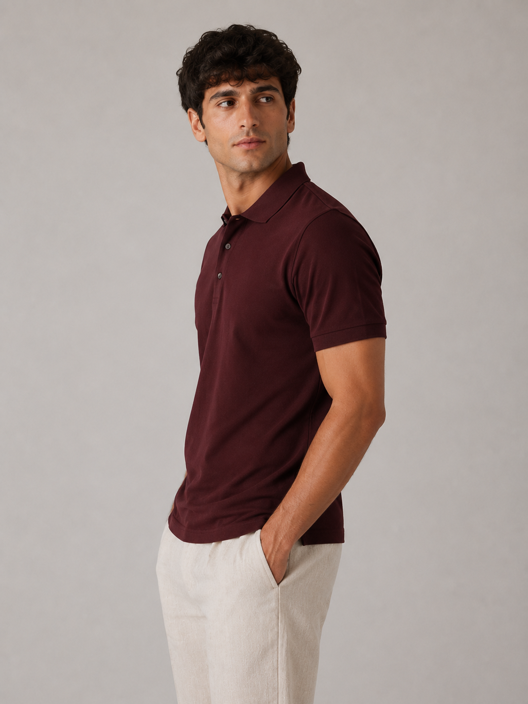 Men’s burgundy red polo shirt, side profile view on model, clean ribbed sleeve cuff fit