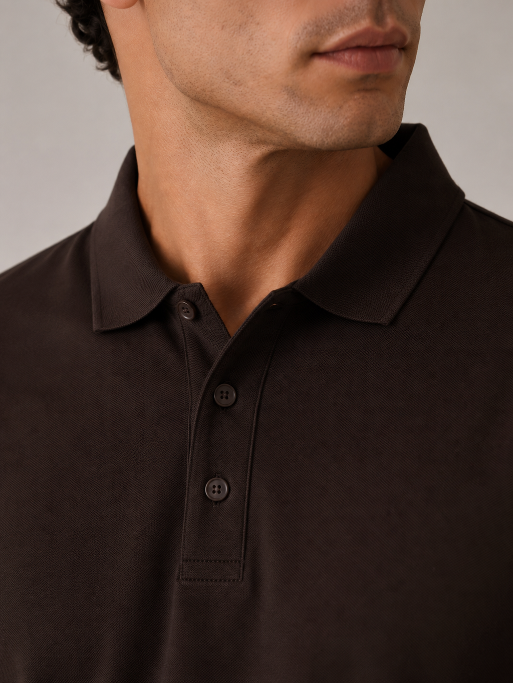 Men’s espresso brown polo shirt, flat lay front view, crisp ribbed collar on neutral surface